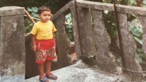 Foto di Andrea, all'età di circa tre anni. Indossa una maglia a maniche corte gialla e dei pantaloncini rossi. Si trova su una terrazza nella vecchia casa di Sanguinetto in provincia di Verona.